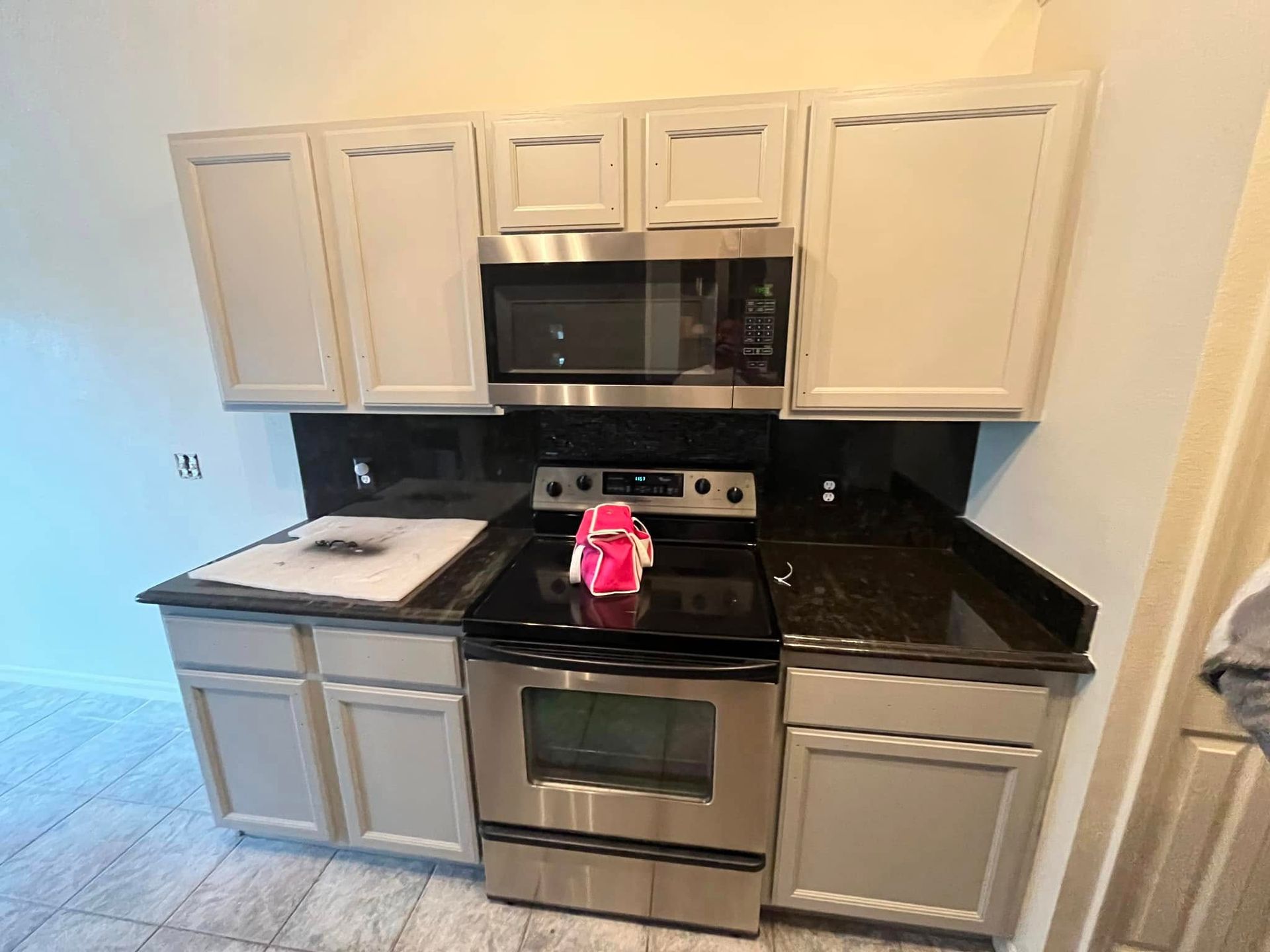 A kitchen with stainless steel appliances and white cabinets.