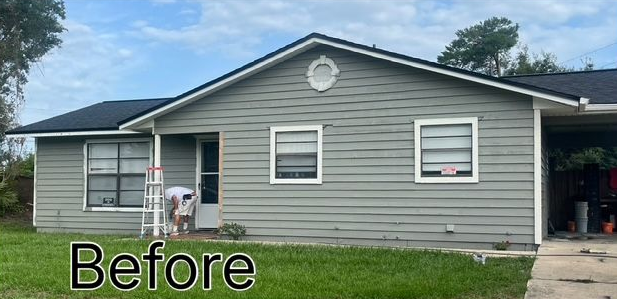 A before picture of a house with a red garage door.