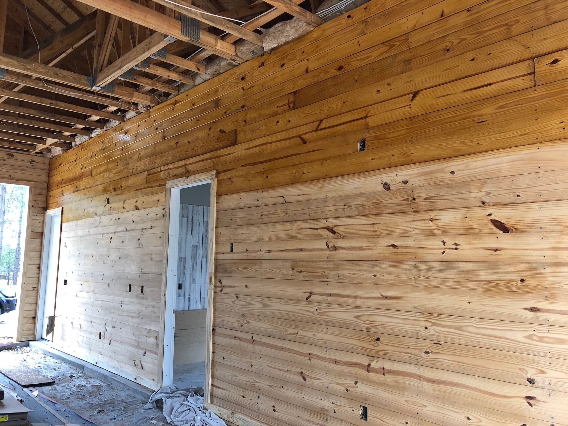 A wooden wall with a door in a building under construction.