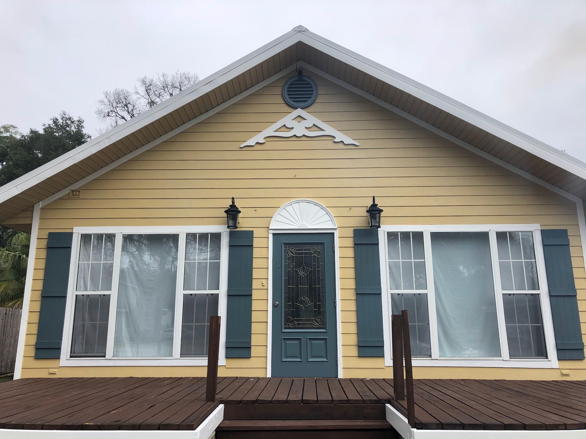 A yellow house with blue shutters and white trim