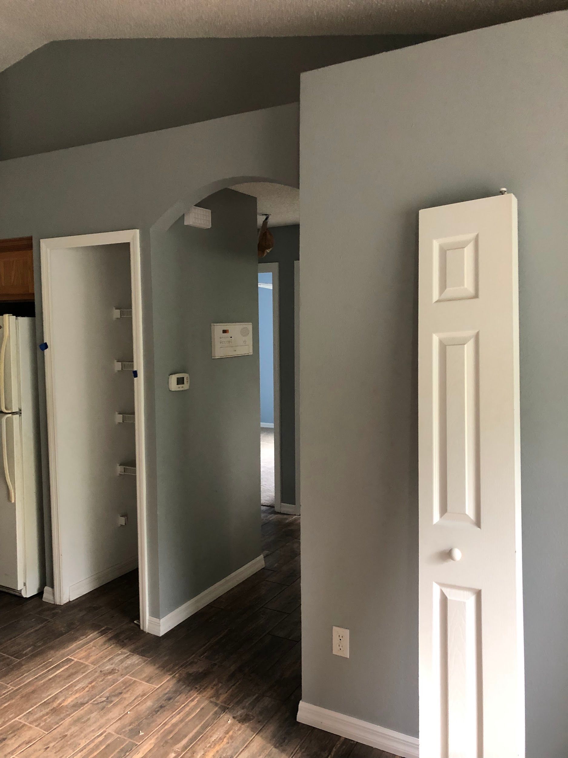 A hallway in a house with gray walls and white doors.