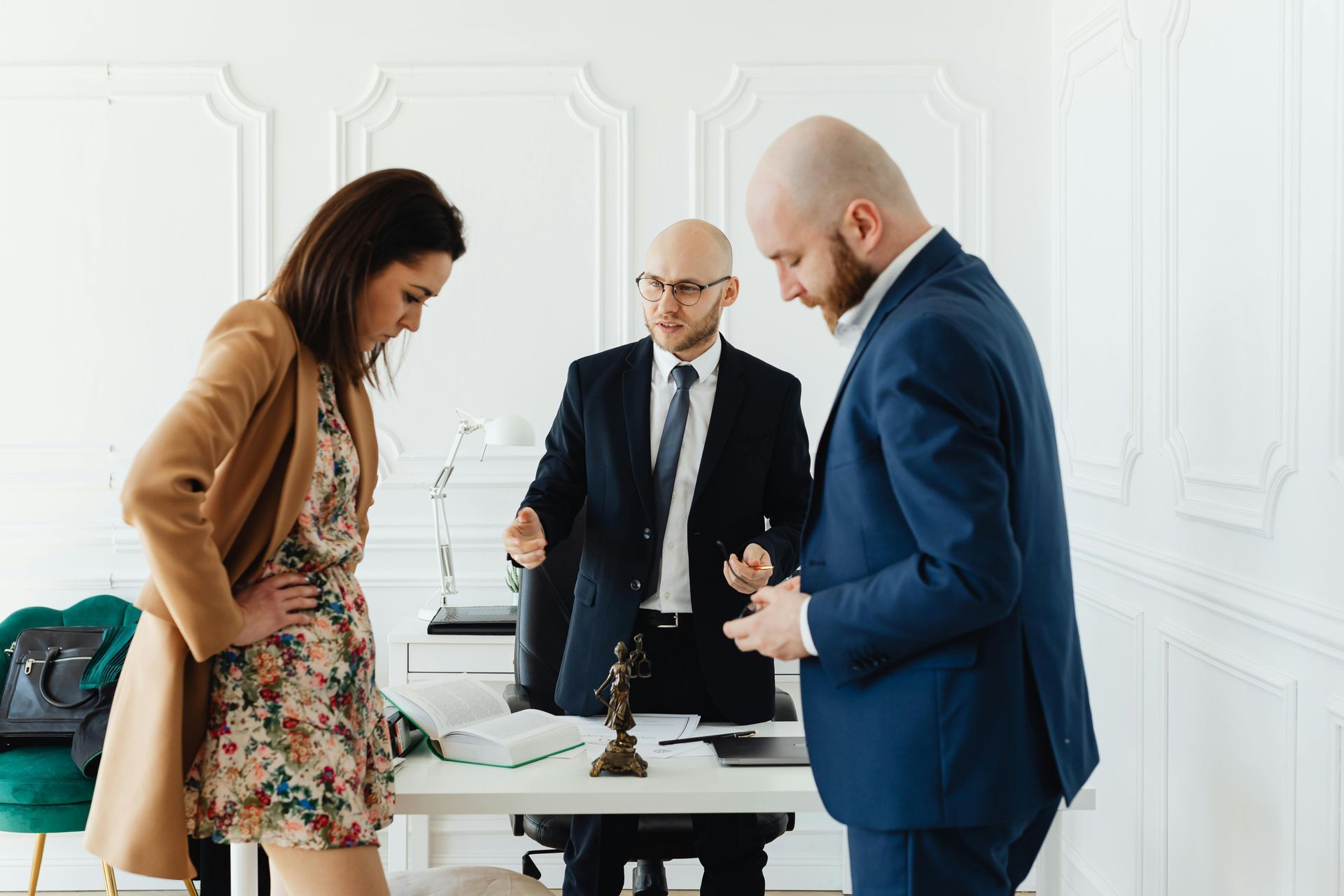 A man in a suit and tie is talking to a woman and a man in a suit and tie.