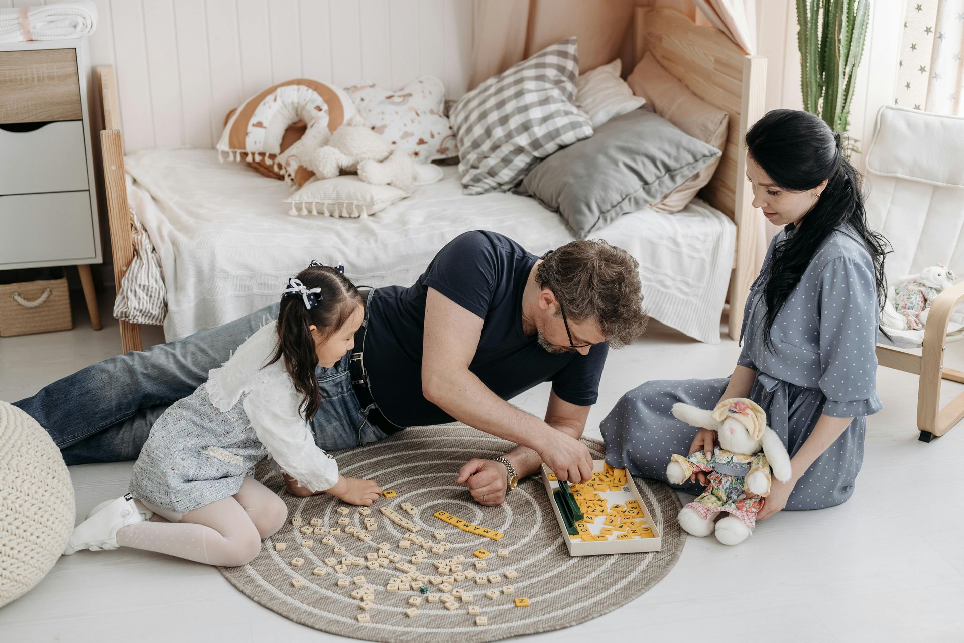 A family is sitting on the floor playing a game.