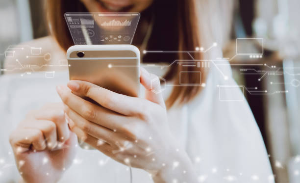 Person holding a smartphone with translucent digital interface icons overlaid on the screen