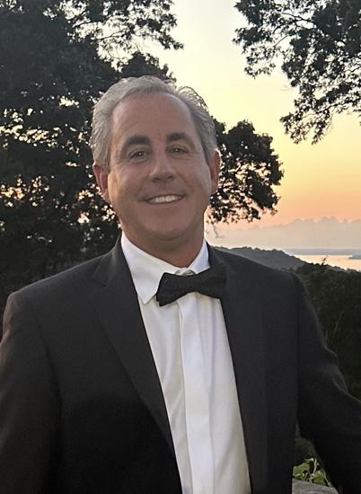 A man in a suit and tie is smiling for the camera.