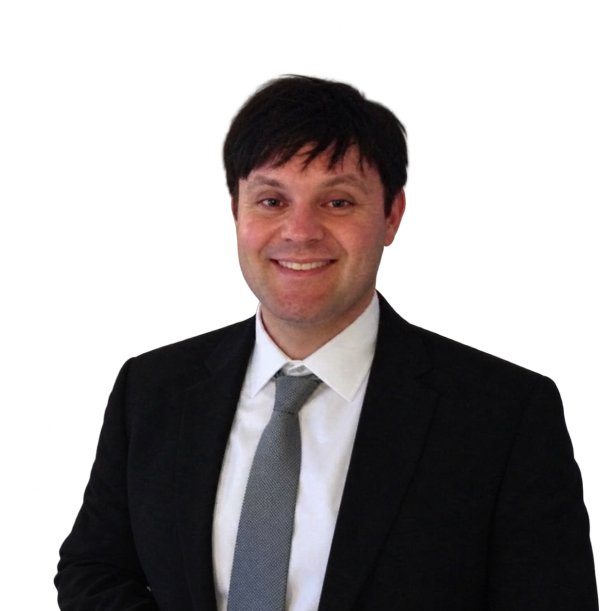 Man in a black suit and tie smiling against a white background