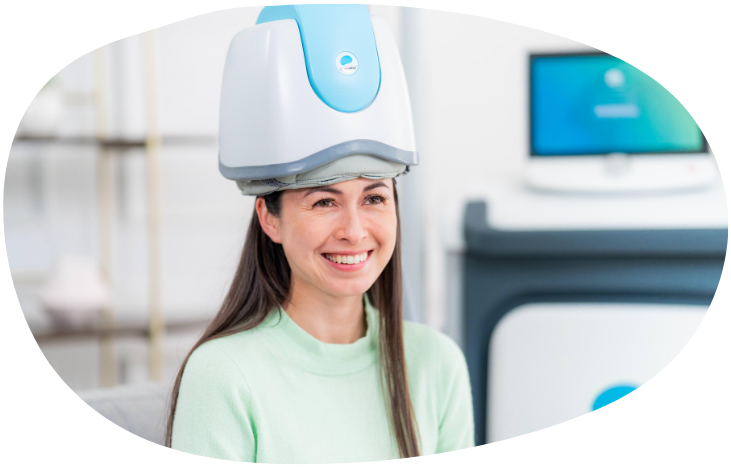 Woman wearing a head-mounted device in a bright clinical setting, smiling softly