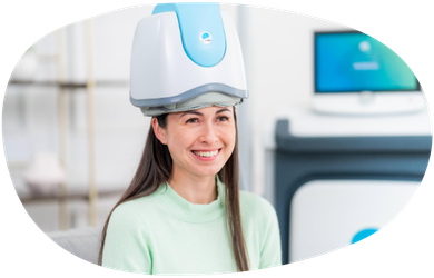 Smiling patient wearing a head-mounted medical device in a bright clinic room