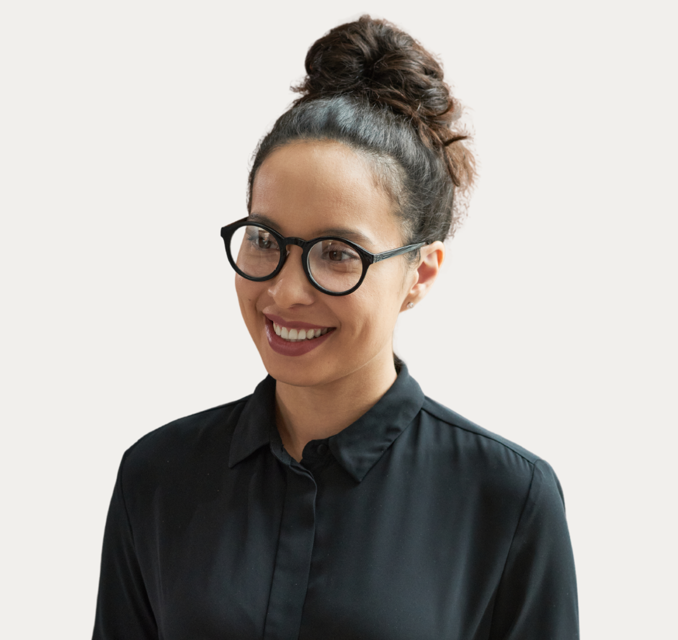 Smiling person with glasses and a black shirt against a light background