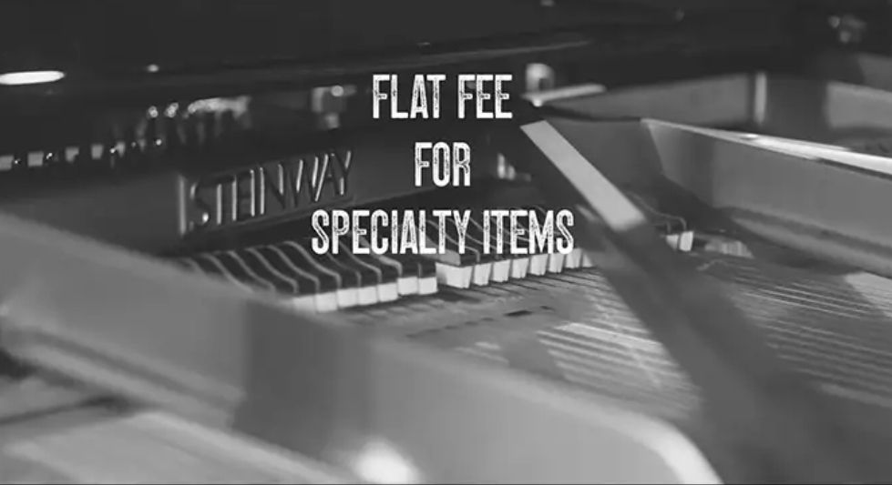 Black-and-white sign reading “Flat Fee for Specialty Items” above a store counter
