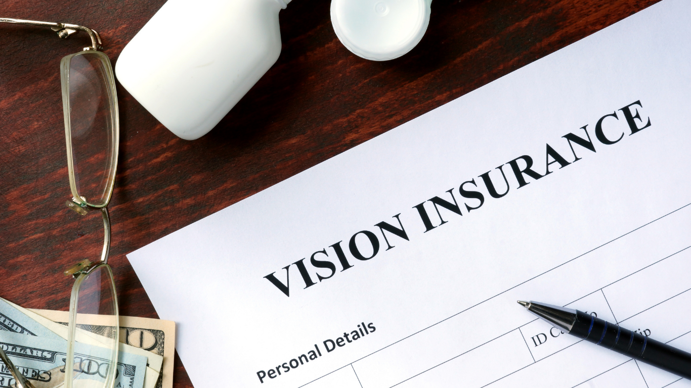Vision insurance form on a desk with glasses and a pen
