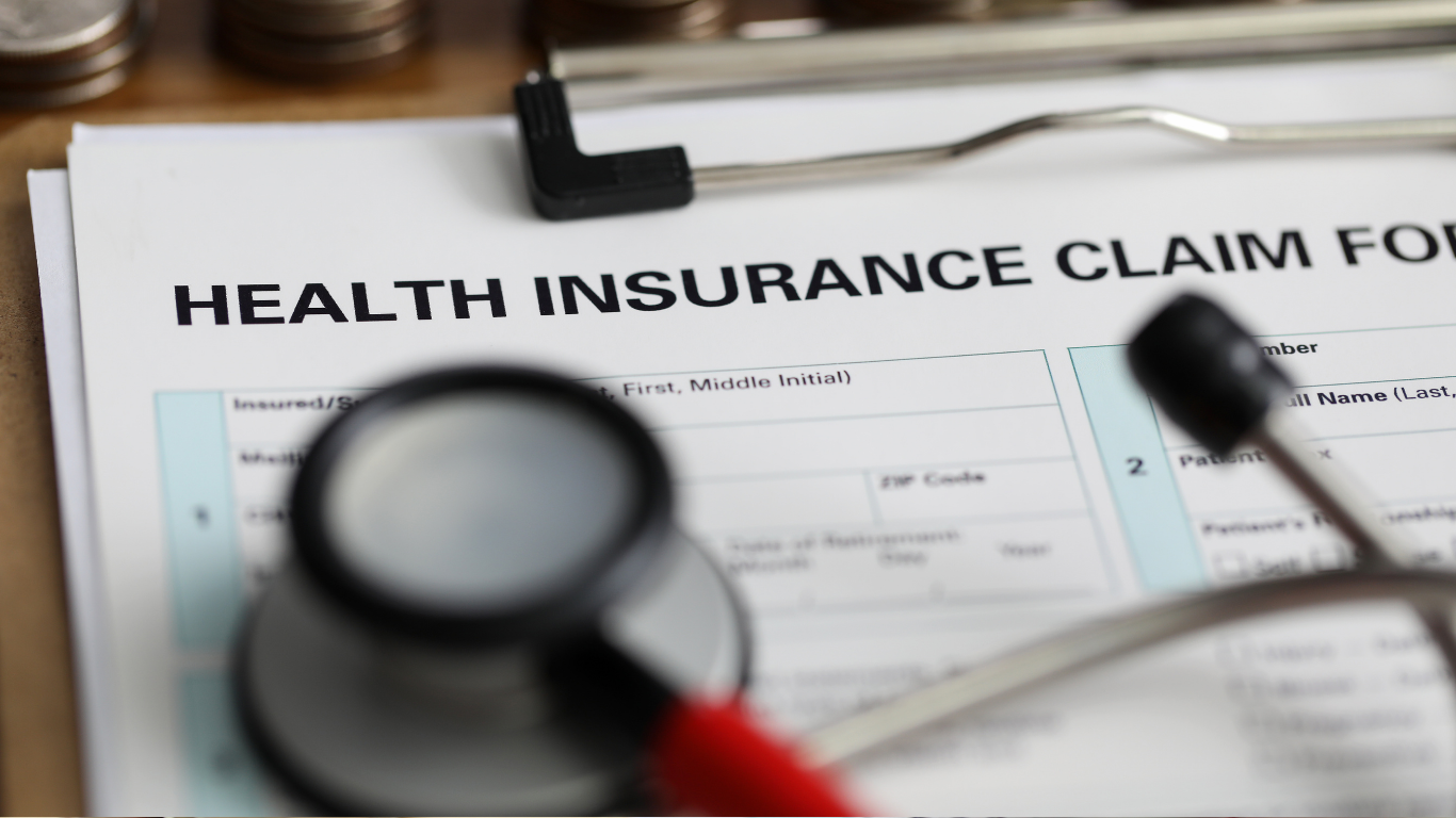 Health insurance claim form with stethoscope and magnifying glass on a desk
