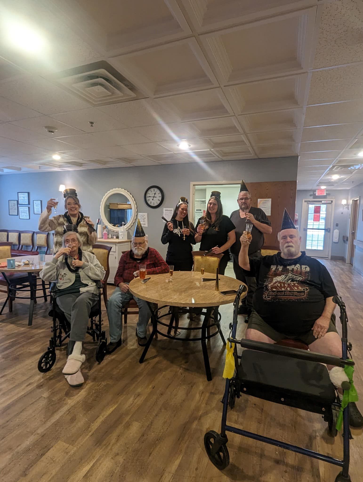 A group of people are sitting at tables in a room in a nursing home.