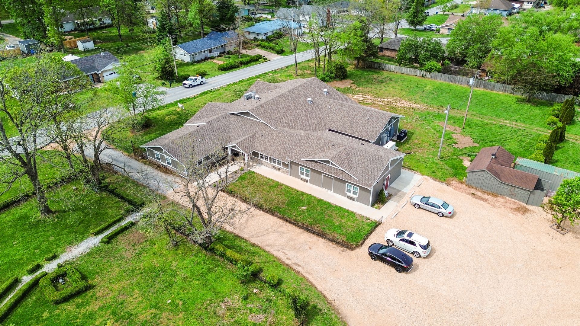 An aerial view of a house with cars parked in front of it.