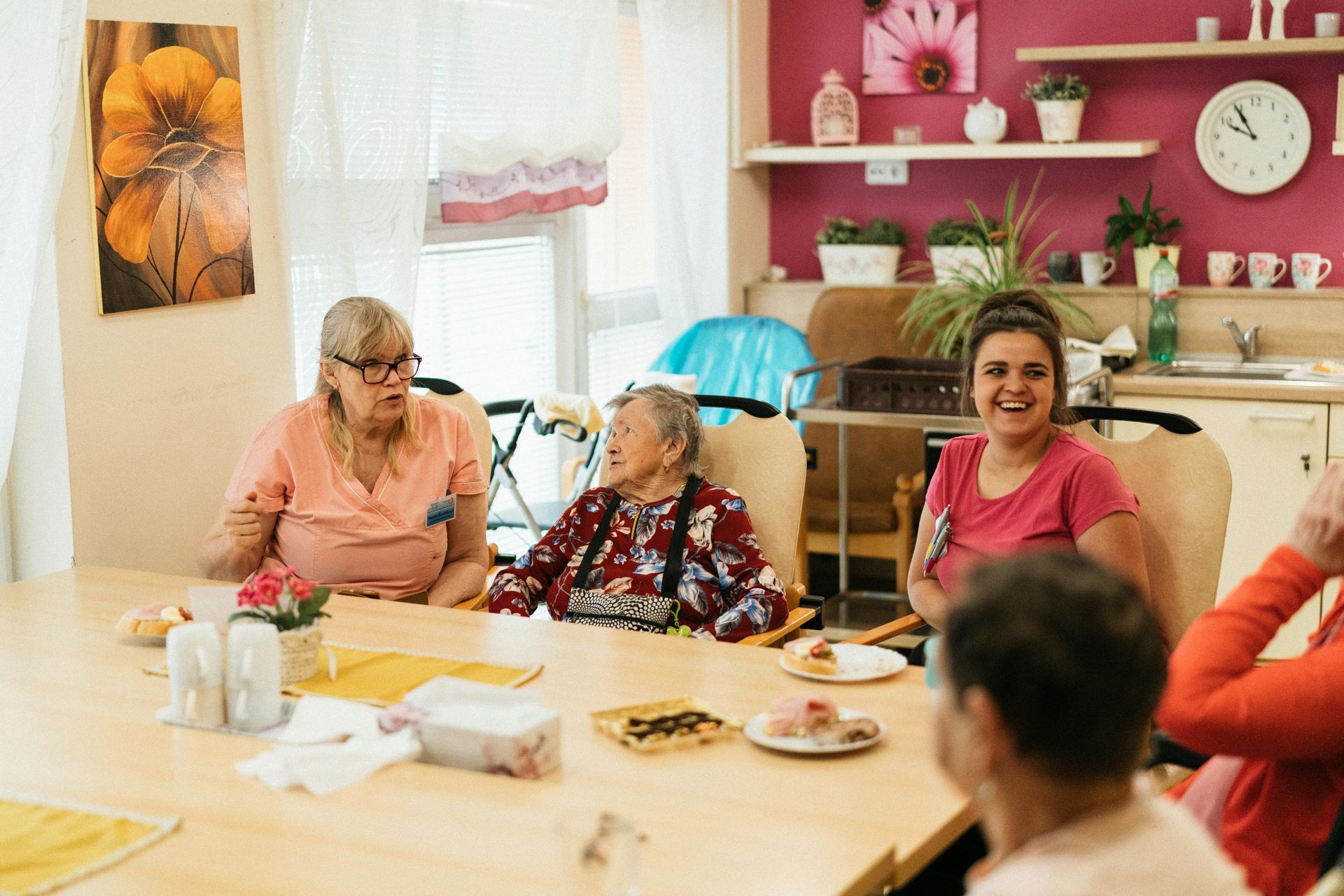 A group of elderly people are sitting around a table in a room.