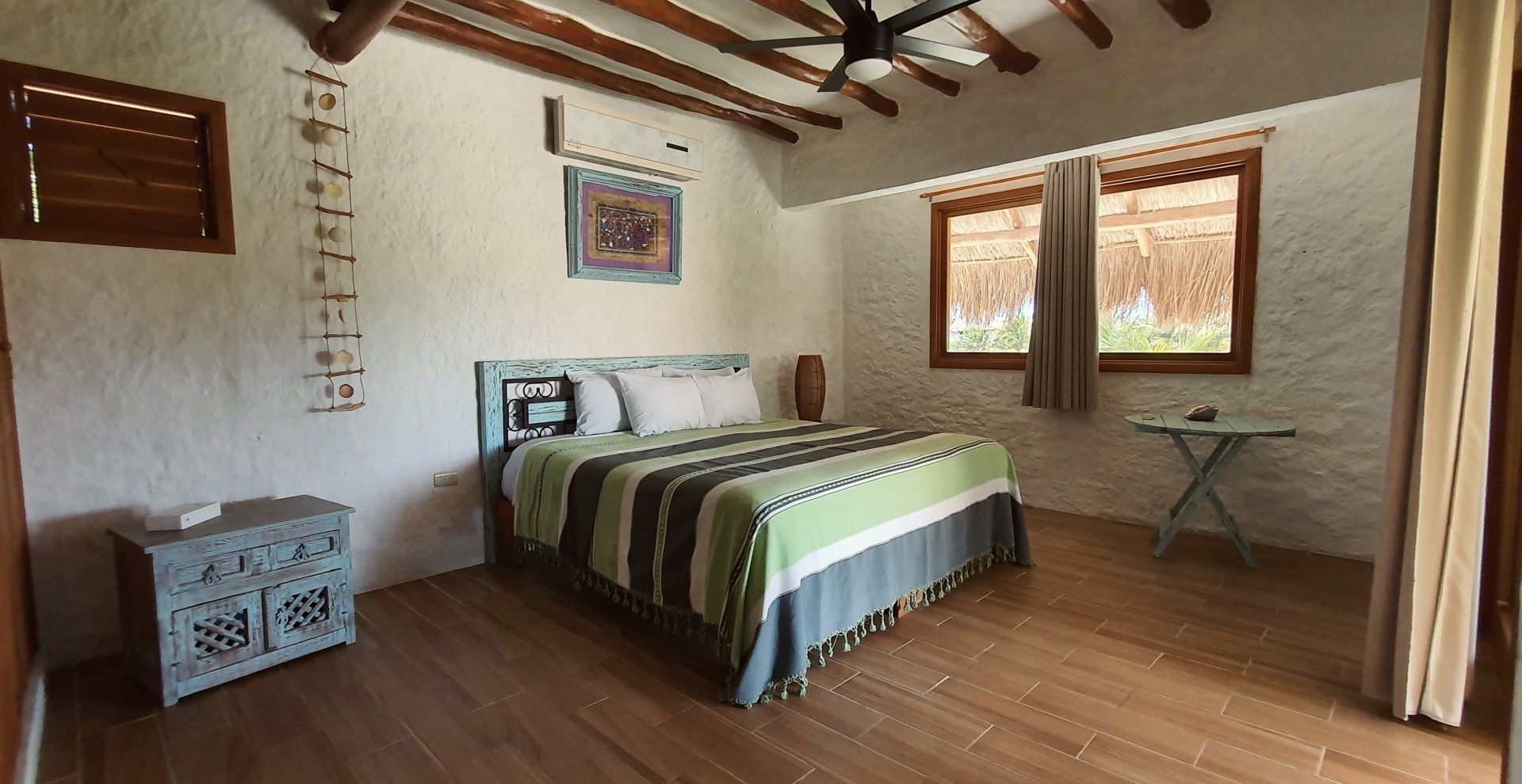 Un dormitorio con una cama grande y un ventilador de techo.