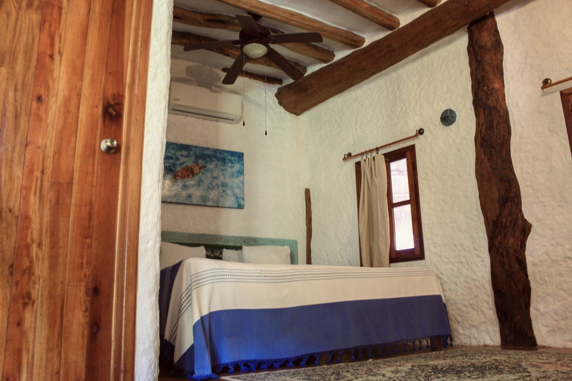 Un dormitorio con una cama y un ventilador de techo.