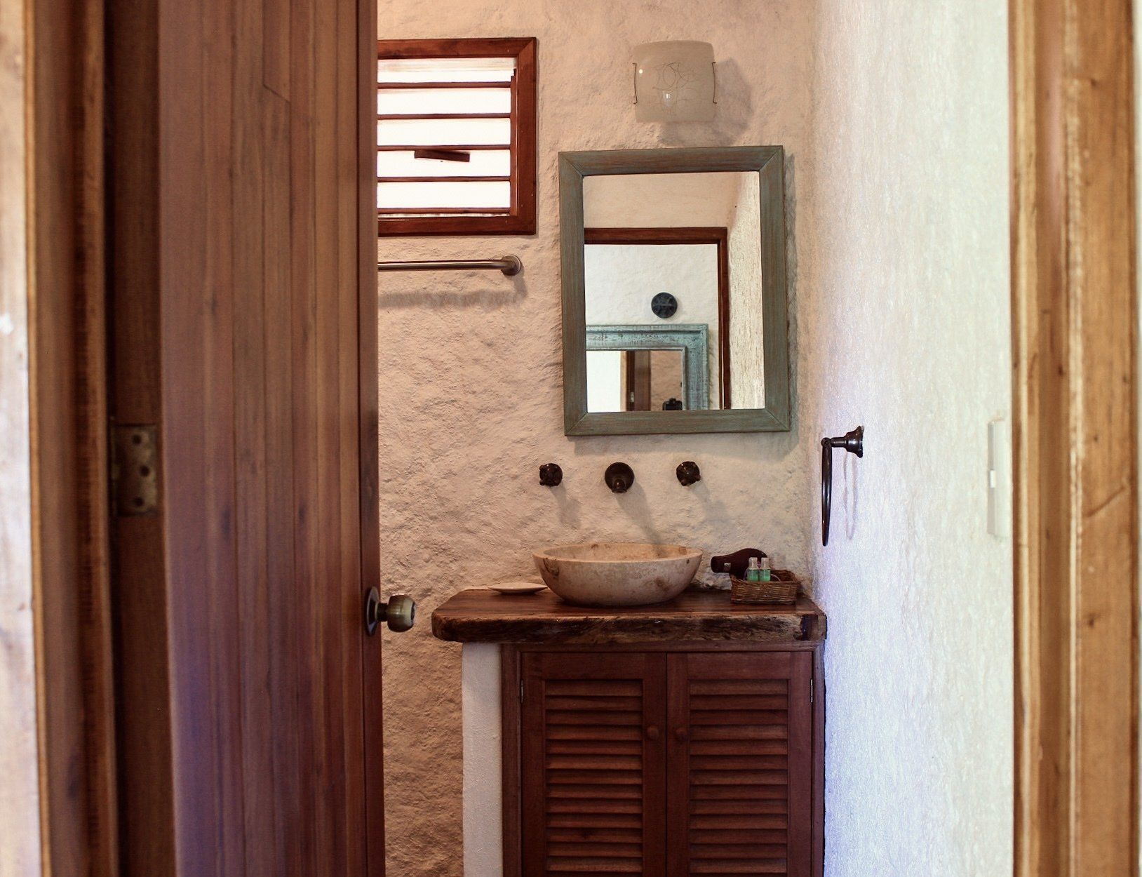 Un baño con un lavabo y un espejo en la pared.
