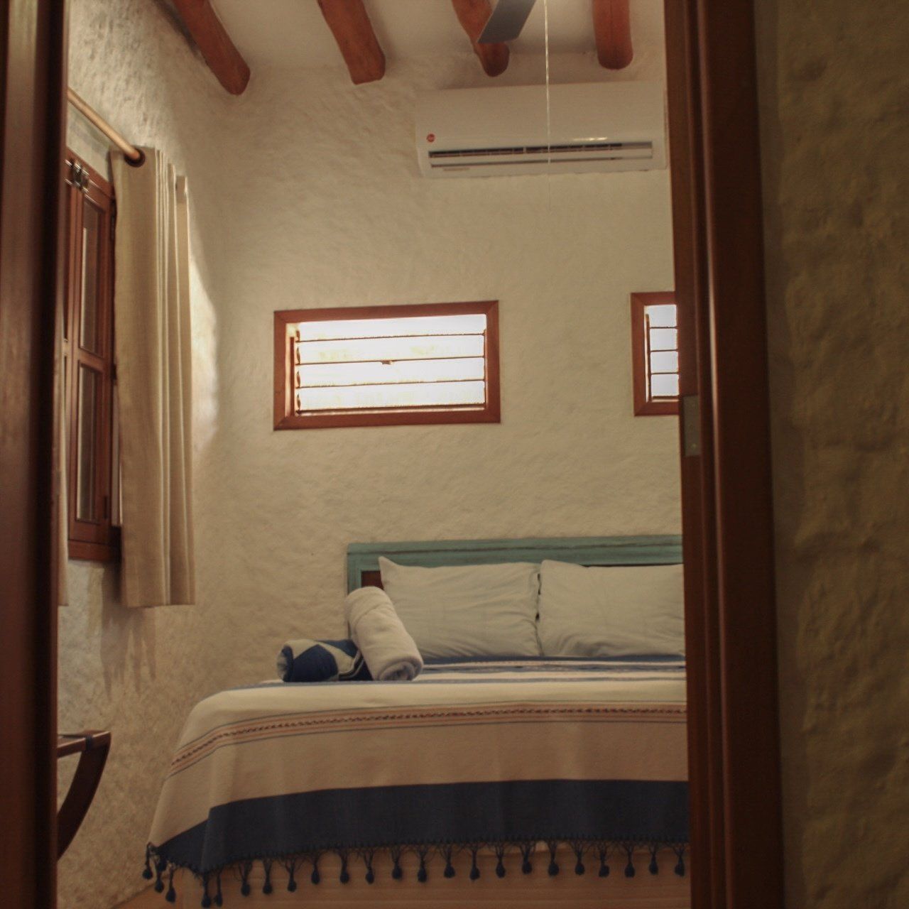 Un dormitorio con una cama king size y dos ventanas.