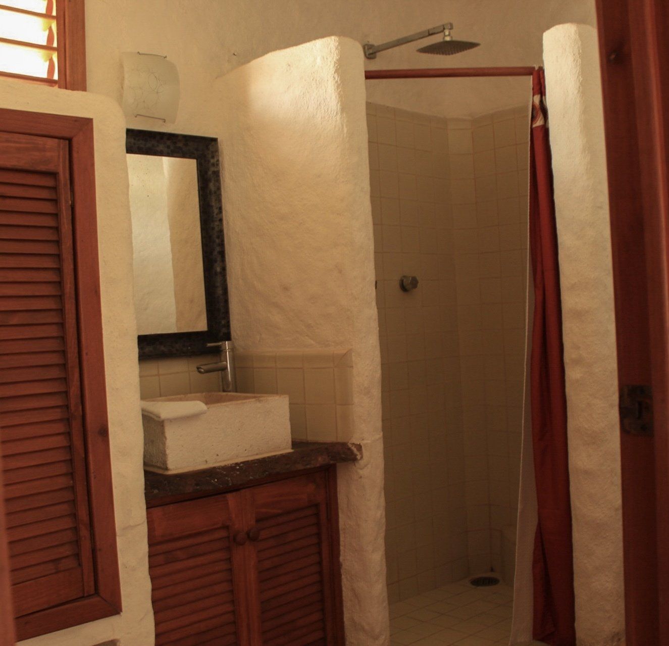 Un baño con lavabo, espejo y ducha.