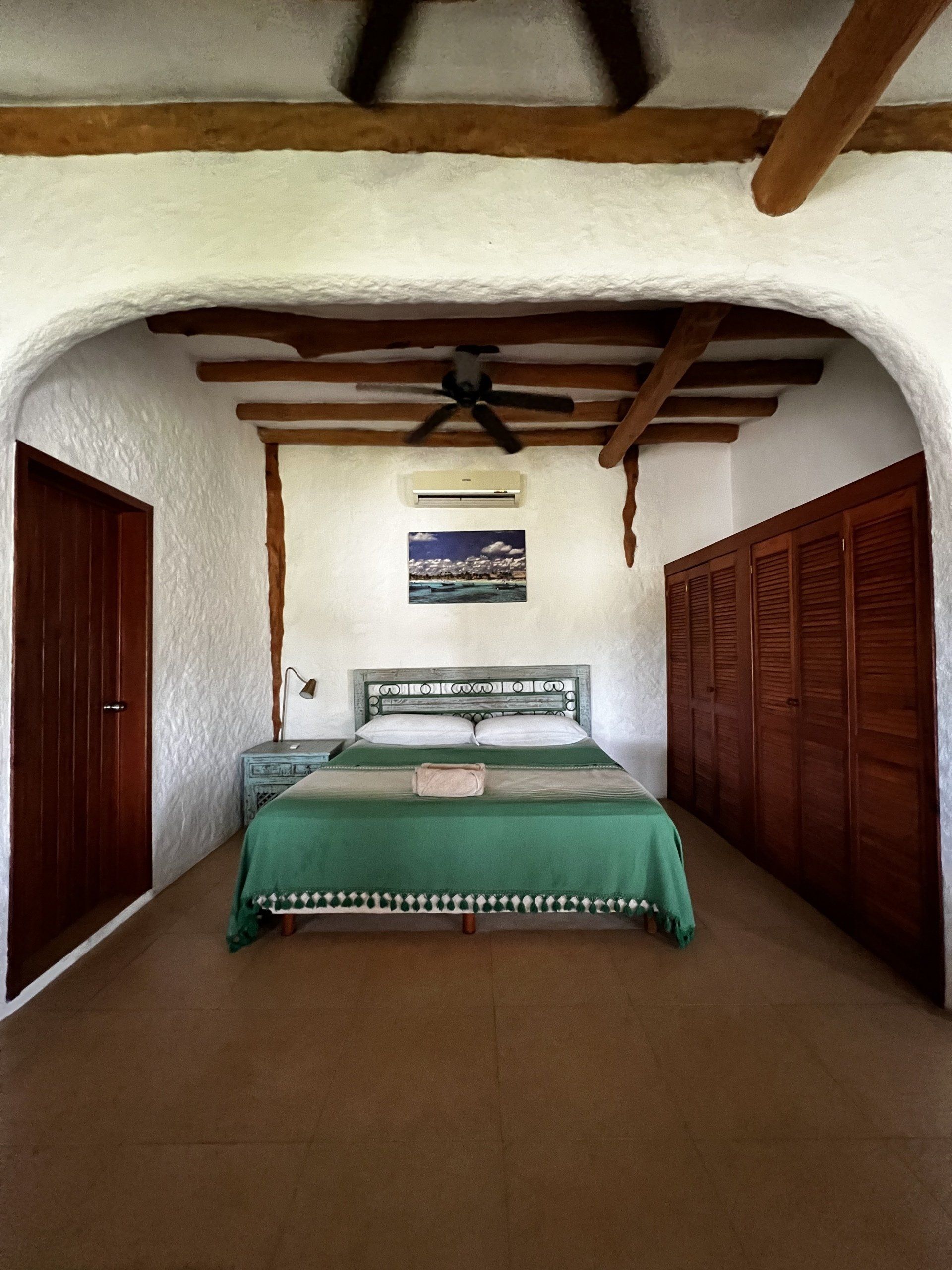 Un dormitorio con una cama y un ventilador de techo.