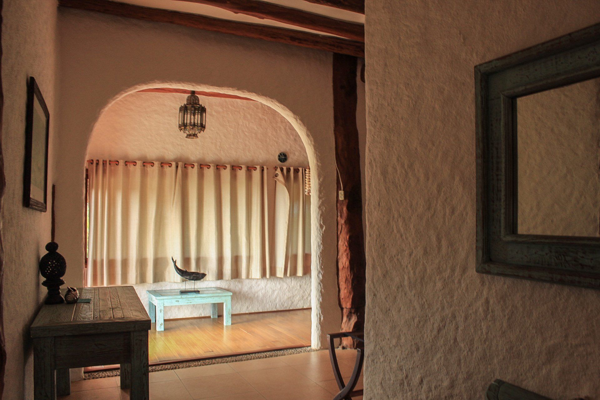 Una sala de estar con una mesa y un espejo.