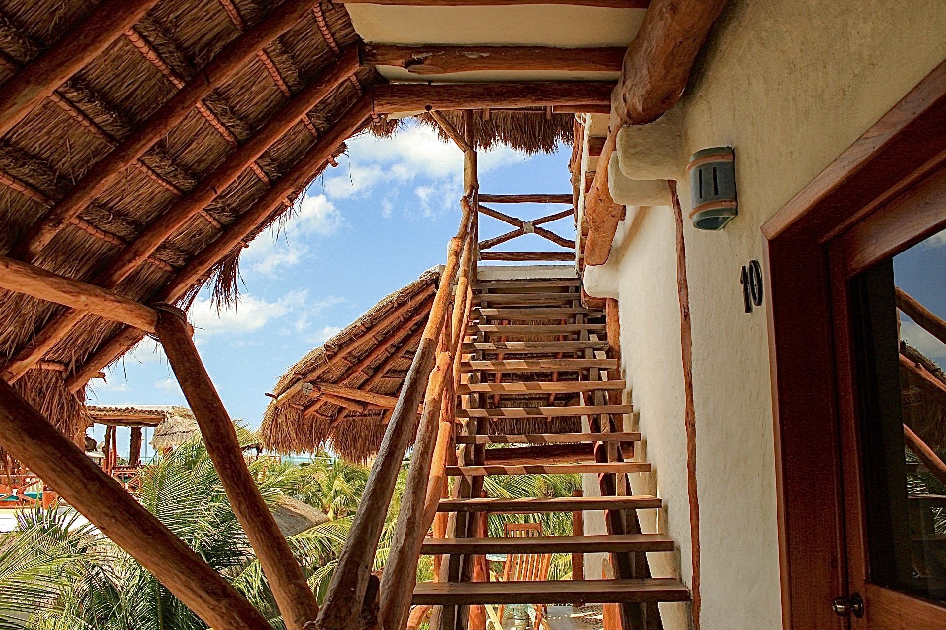 Un conjunto de escaleras de madera que conducen a un techo de paja.