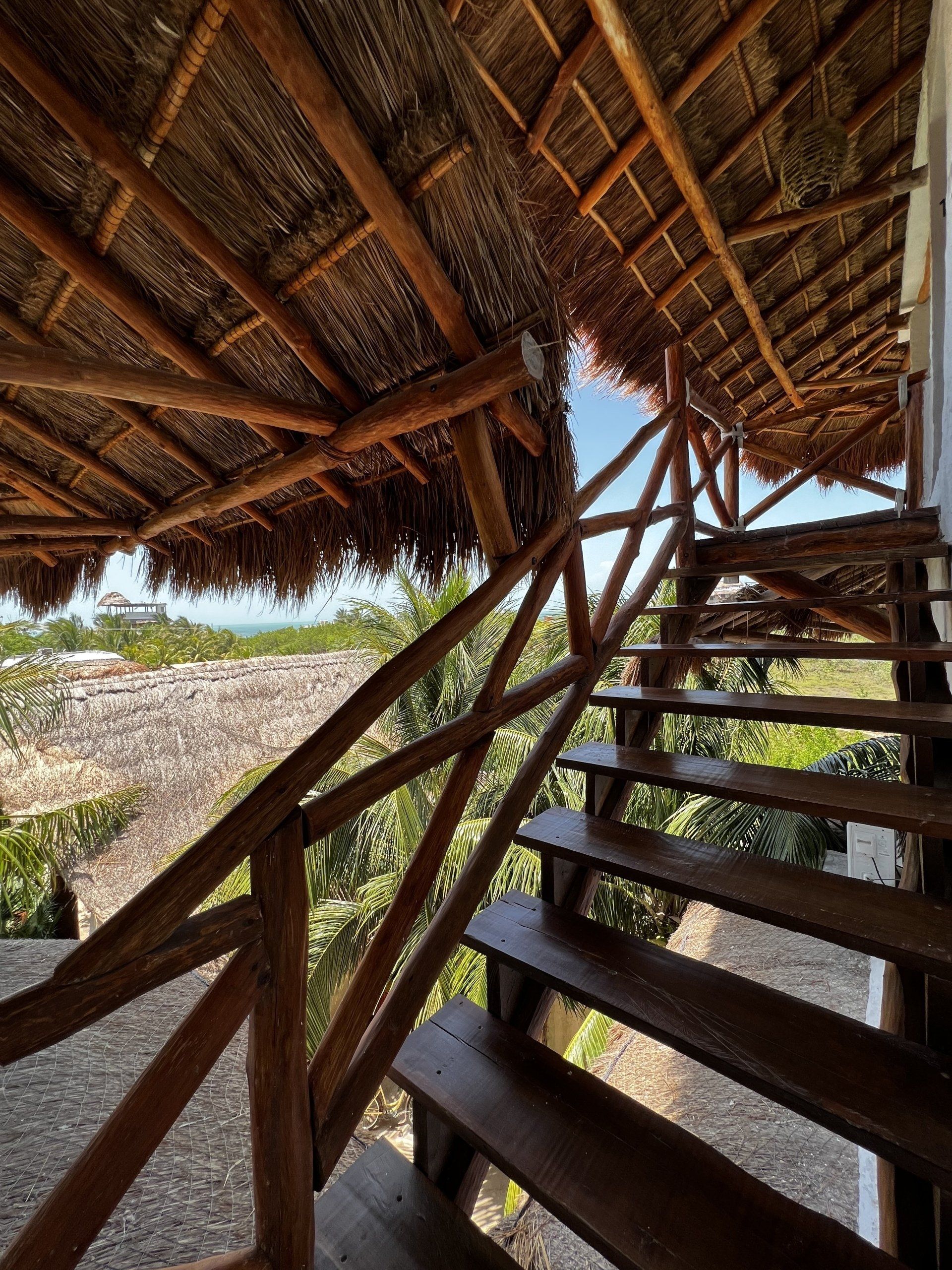Un conjunto de escaleras de madera que conducen a un techo de paja.