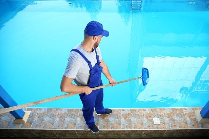Pool cleaner using a net in a bright blue swimming pool