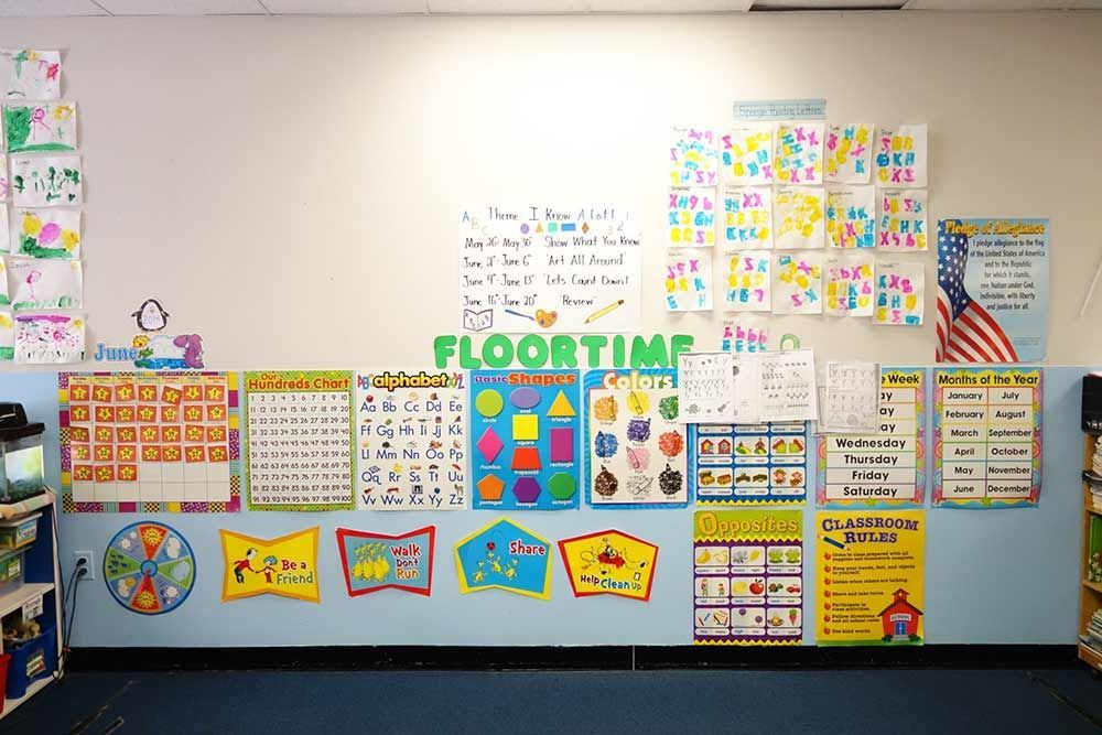 Classroom wall display with colorful educational charts, posters, and a “FLOORTIME” banner