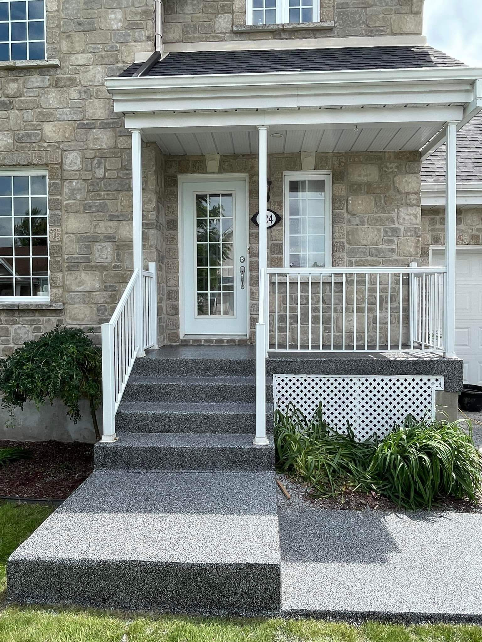 The front of a brick house with a porch and stairs.