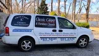 A classic carpet and furniture cleaners van is parked on the side of the road.