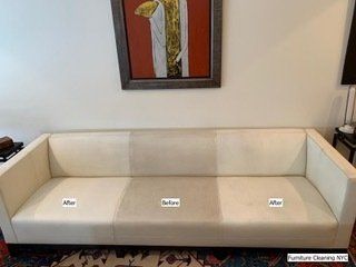 A white couch is sitting in a living room next to a painting.