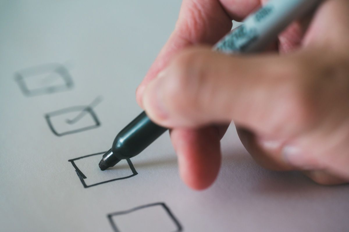 close up and selective focus hand using pen to making tick mark on check list
