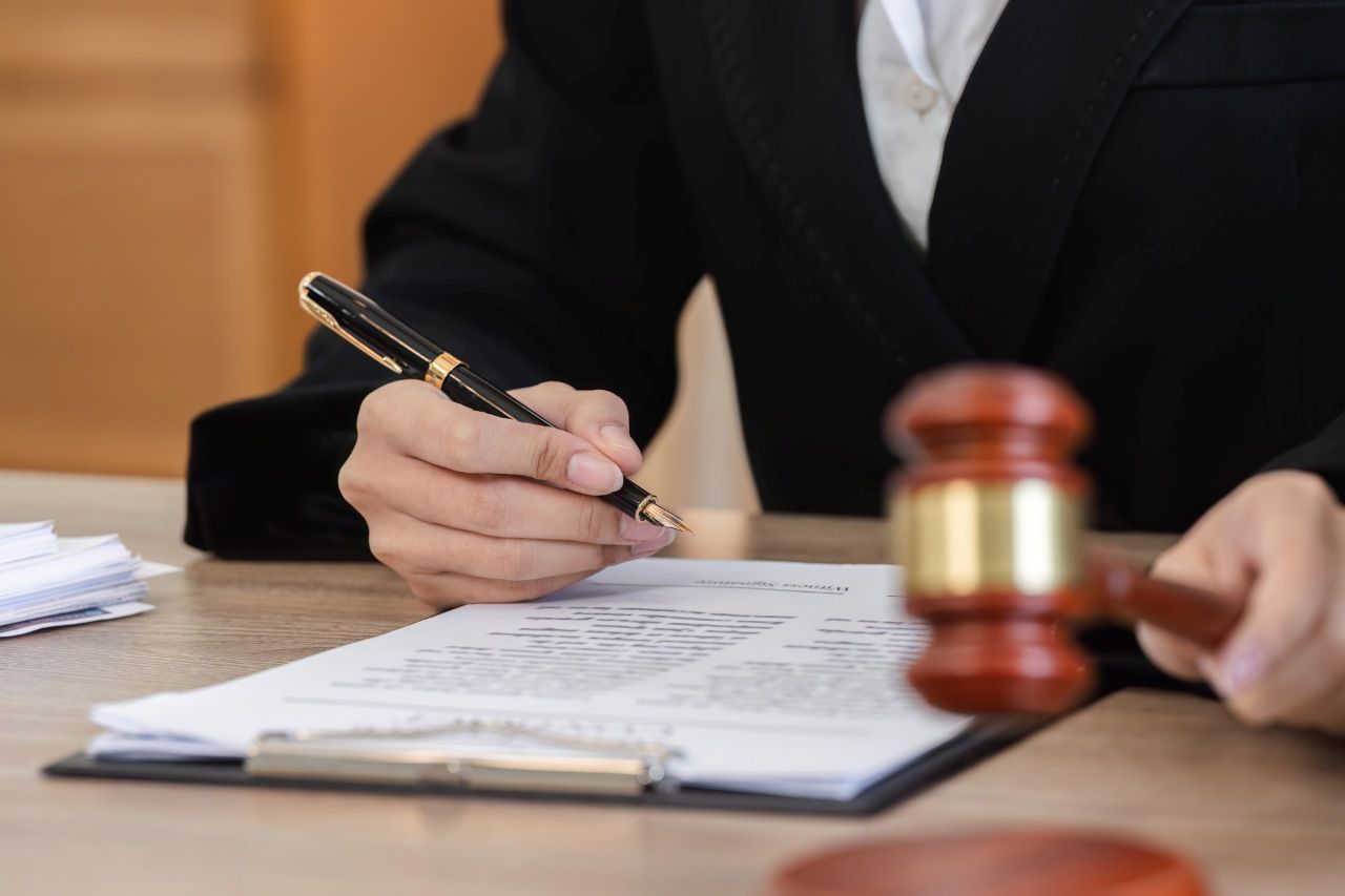 Female Lawyer Reviewing Legal Documents while holding a pen and gavel