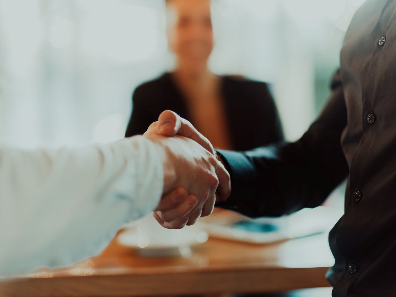 Business people or lawyers shaking hands finishing up meeting or negotiation