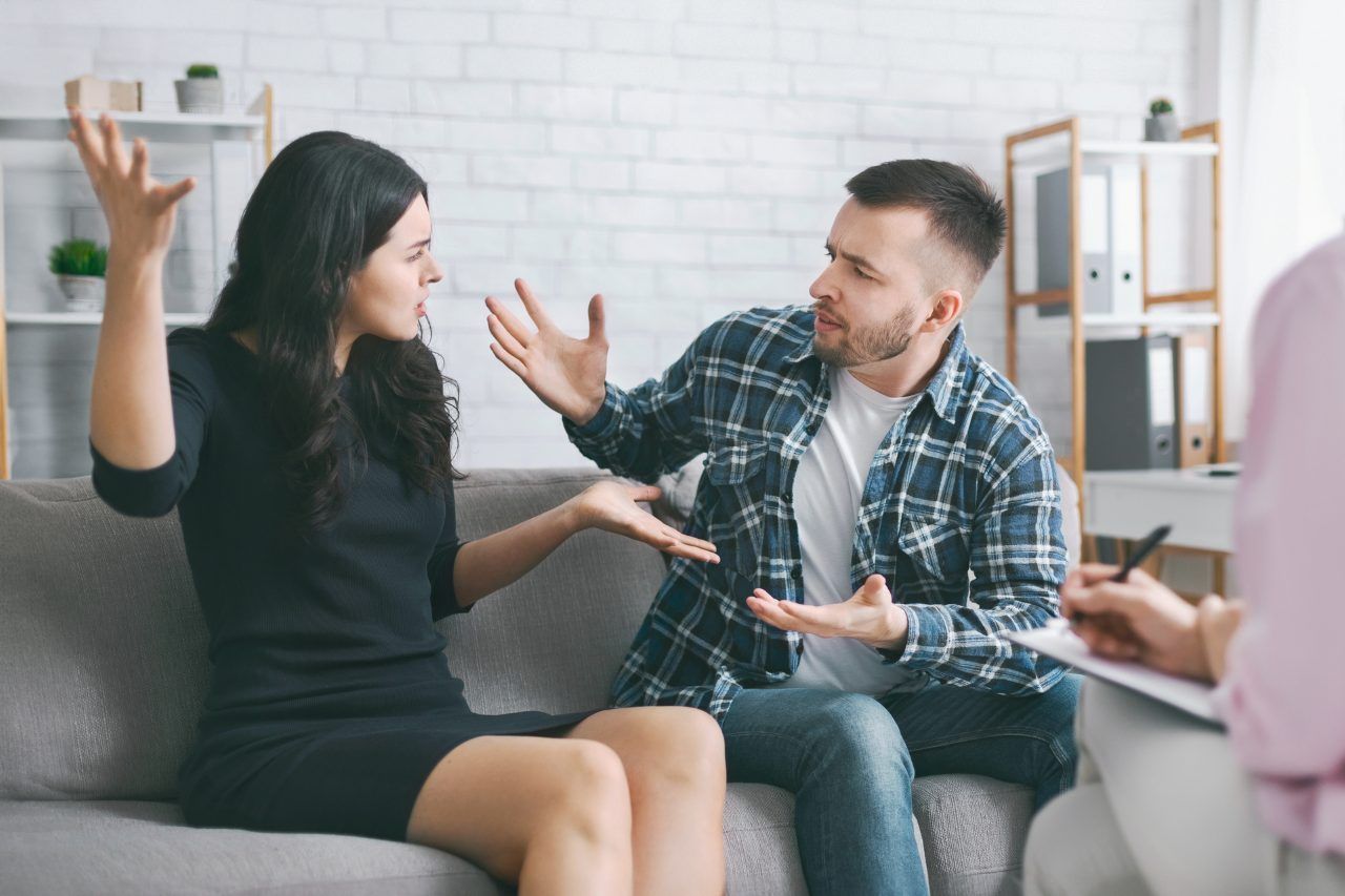 couple sitting on a couch arguing