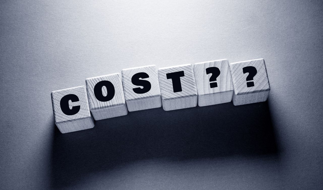 word cost spelled on white wooden cubes