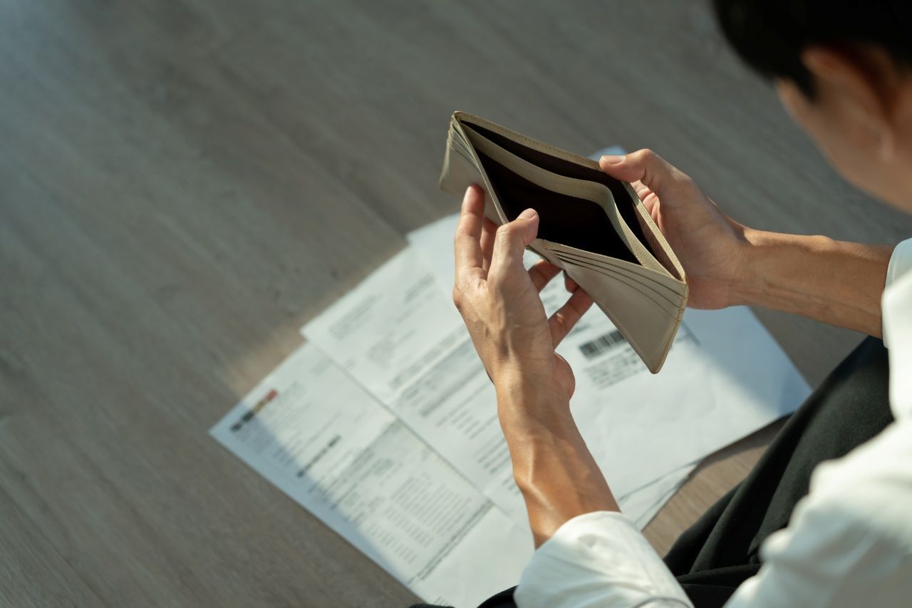 man looking down on his empty wallet