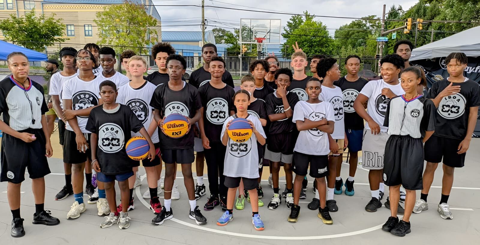Group of IBOA 3x3 youth basketball players on an outdoor court after training.
