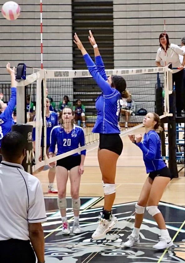 A group of women are playing volleyball on a court.
