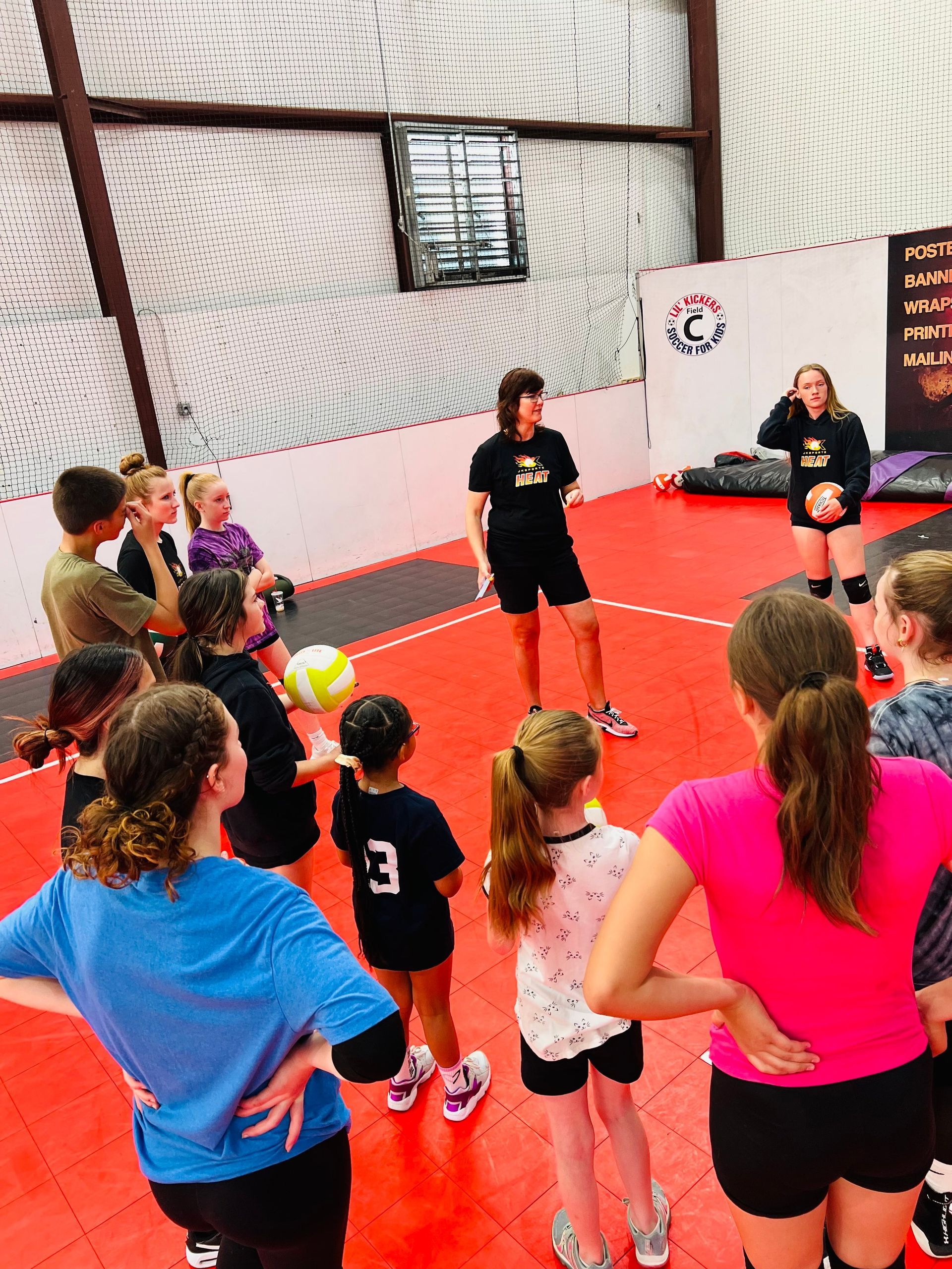A group of people are standing in a circle in a gym.