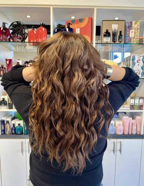 Close up of the back of the head showing long flowing brunette hair achieved with natural hand tied hair extensions.