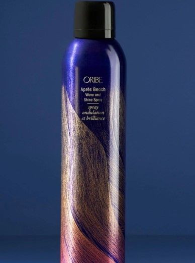 Tall dark blue bottle & waves of swirling blonde hair with Oribe Apres Beach Wave & Shine Spray printed on it.