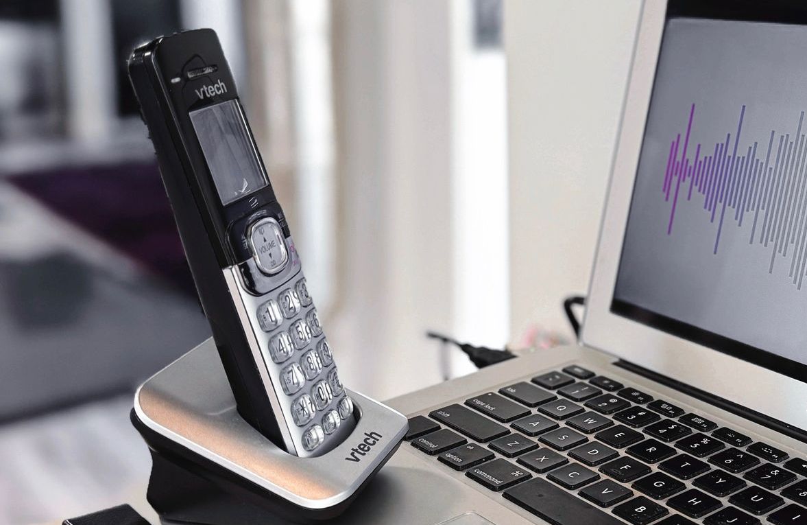 Visualization showing an embodiment of a hair salon AI Phone Assistant with a standard cordless phone being held and spoken to by a laptop.