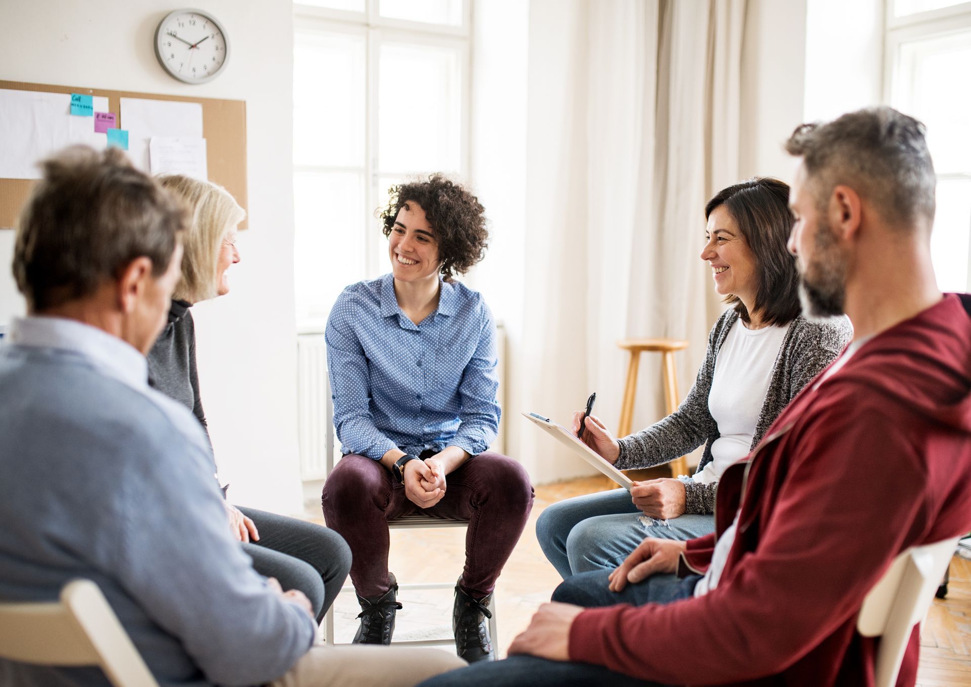 A group of people are sitting in a circle talking to each other.