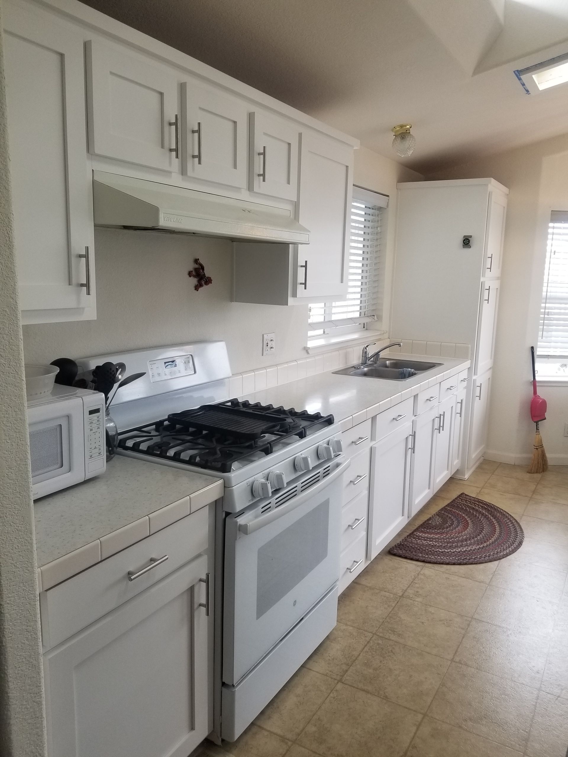 Kitchen with white cabinets, stainless steel appliances, and a wood island. Kitchen with white cabinets, stainless steel appliances, and a wood island.