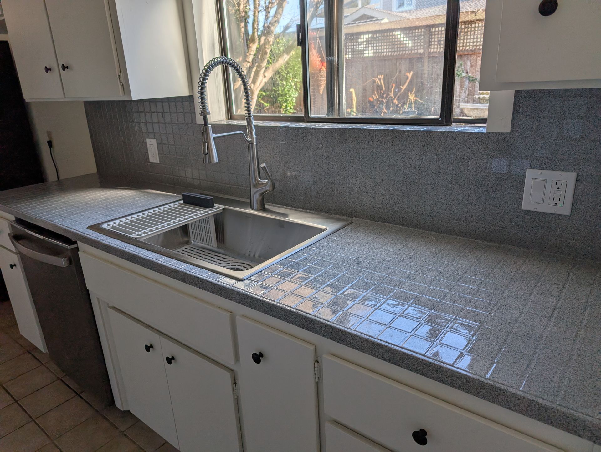 Modern white kitchen with island seating, stainless steel appliances, and wood floors. Modern white kitchen with island seating, stainless steel appliances, and wood floors.