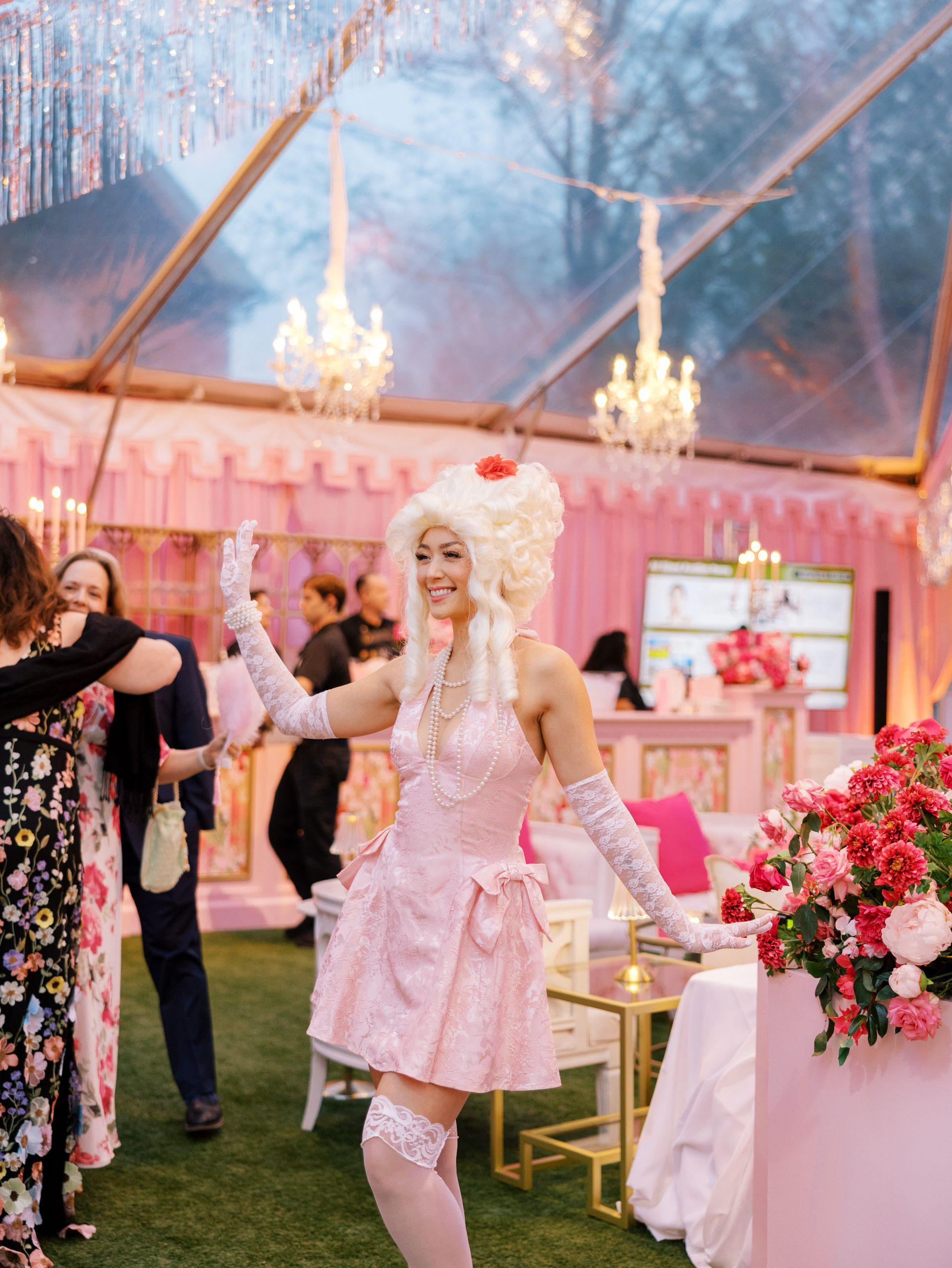 Four women in colorful outfits hold a large check at a festive nighttime celebration of An Evening To Ignite at Merrimon-Wynne in Raleigh, NC.