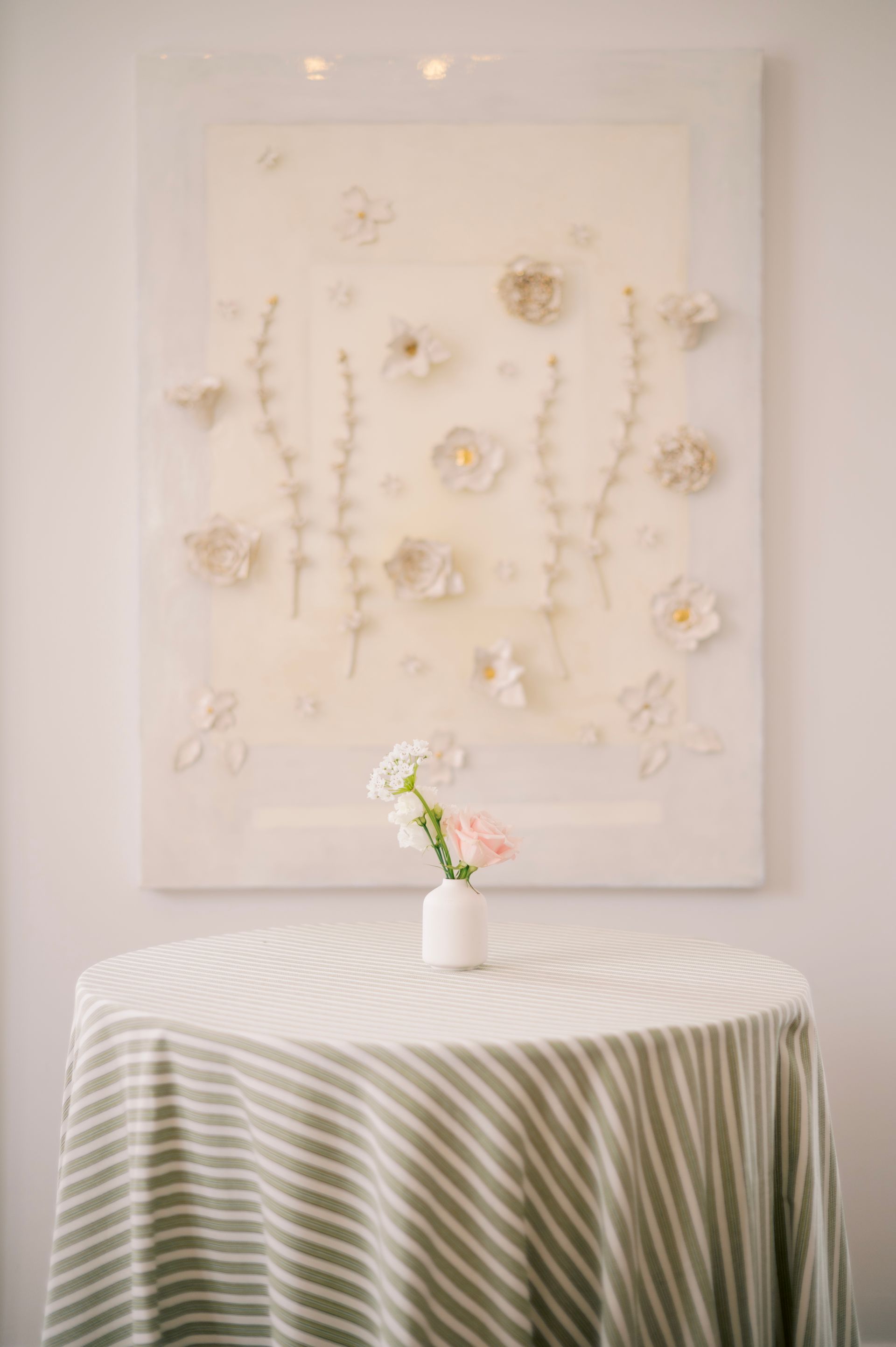 A wooden staircase inside a room, decorated with a lush, leafy green garland draped along the white banister.